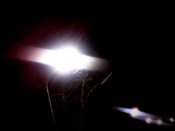 Close-up of illuminated lights against sky at night