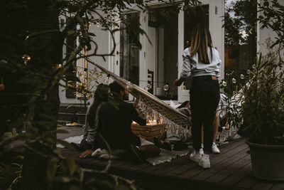 Rear view of people standing by trees
