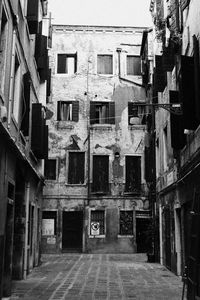 Alley amidst old buildings in city against sky