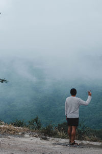 Rear view of man standing on mountain