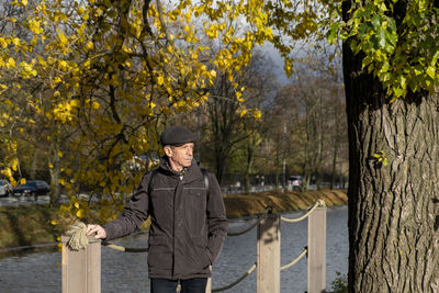 Portrait of man standing by tree