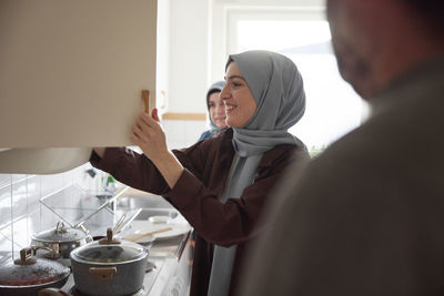 Women in headscarves cooking together for eid al-fitr at home