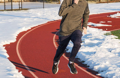 Low section of man on snow covered land