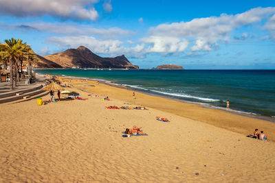 People on beach against sky