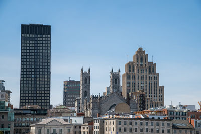 Buildings in city against blue sky