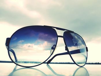 Close-up of sunglasses against sky