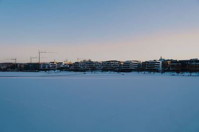 Snow covered buildings against clear sky