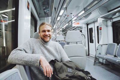 Portrait of smiling man sitting in train