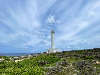 Lighthouse by sea against sky