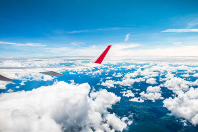 Airplane flying over sea against blue sky