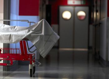 Dead person covered with sheet gurney in hospital corridor