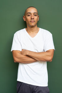 Portrait of young man standing against wall