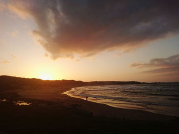 Scenic view of beach against sky during sunset