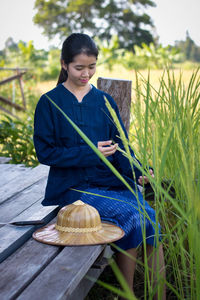 Asian woman sitting on pier