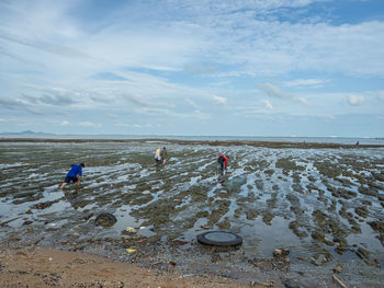 People on beach against sky