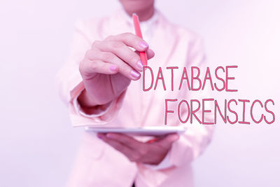 Midsection of woman holding pink text against white background