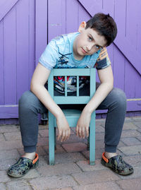 Portrait of smiling boy sitting outdoors