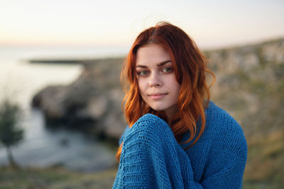 Portrait of beautiful young woman against sky