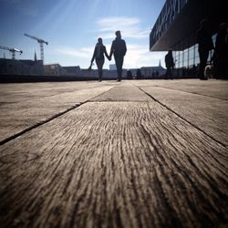 Surface level view of couple walking on wooden walkway