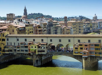 Bridge over river amidst buildings in city