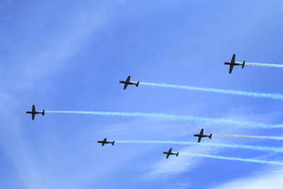 Low angle view of airplane flying against blue sky