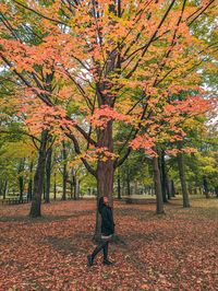 Rear view of woman walking on field during autumn