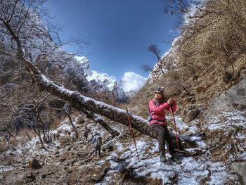 Woman standing on rock against sky during winter