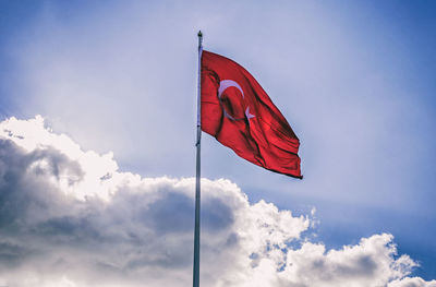 Low angle view of flag waving against sky