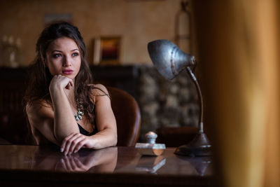 Portrait of young woman sitting on table