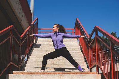 Low angle view of woman against blue sky