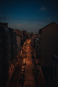 Illuminated buildings in city against sky at dusk