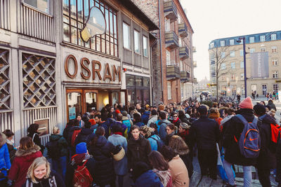 People on street against buildings in city