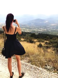 Rear view of woman standing on land