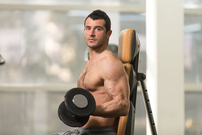 Shirtless muscular man exercising in gym