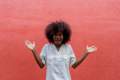 Portrait of woman standing against red background