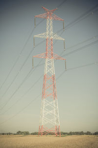 Electricity pylon on field against sky