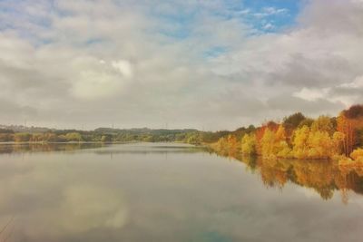 Scenic view of calm lake against cloudy sky