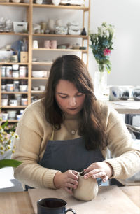 Pottery workshop class. a popular hobby is making ceramic dishes from a raw clay. selective focus.