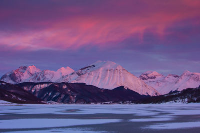 Scenic view of snowcapped mountains against sky during sunset