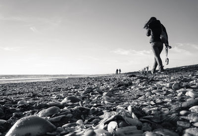 Surface level of pebbles on beach against sky