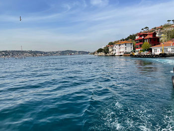 Scenic view of sea by buildings against sky