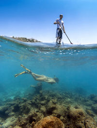 Young couple have a fun in ocean water, underwater view