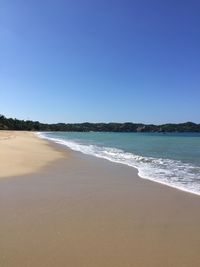 Scenic view of beach against clear blue sky