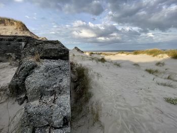 Scenic view of rocks on shore against sky