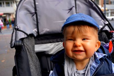 Close-up of smiling cute baby boy sitting in stroller