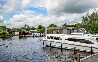 Houses by river against sky