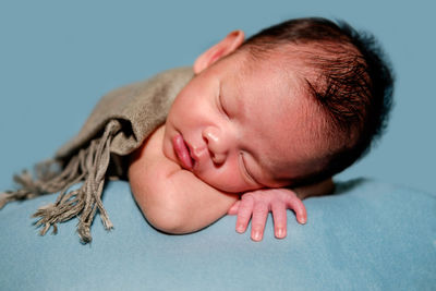 Close-up of cute baby sleeping on bed