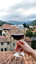 Cropped hand holding wine glass.