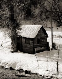 House on snow covered field by building