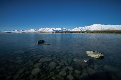 Scenic view of frozen lake against blue sky